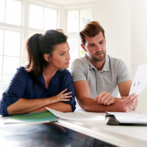 Couple Looking At Domestic Finances At Home Together - Shape Software - Automate your business! - Shape Software - Automate your business!